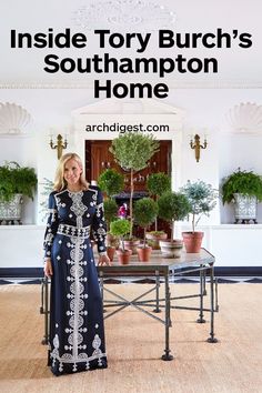 a woman standing in front of a table with potted plants on it and the words inside tony burch's southampton home