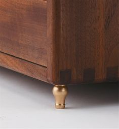 a wooden dresser with brass knobs on it's drawer and bottom drawers, against a white background