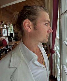 a man standing in front of a window looking out