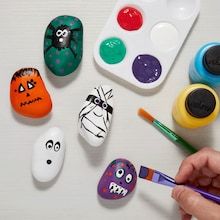 someone is painting rocks with different colors and designs