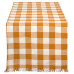 an orange and white checkered tablecloth with fringes on it, against a white background