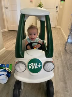 a small child in a toy car on the floor