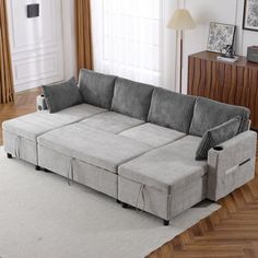 a living room with a gray couch and white rug