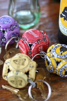 several different colored bottle openers sitting next to each other on a wooden table with a wine bottle in the background