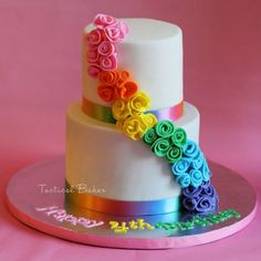 a white cake with multi colored flowers on top