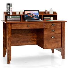 a wooden desk with a laptop on top of it next to books and other items