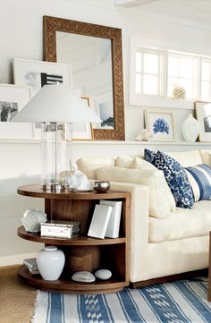 a living room filled with furniture and a mirror on the wall above it's coffee table