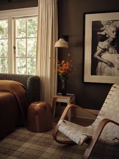 a living room filled with furniture next to a window covered in curtains and drapes