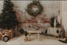 a room decorated for christmas with presents and wreaths on the brick wall behind it