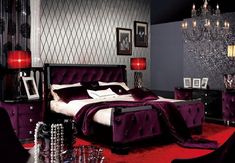 a bedroom decorated in purple and black with chandelier hanging from the ceiling, red carpeted area rugs on the floor