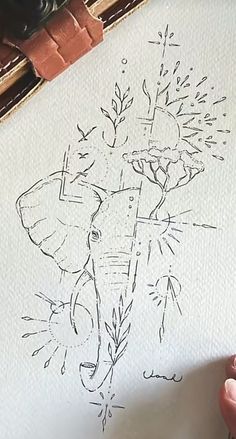 a drawing of an elephant with flowers in it's trunk is being drawn on paper