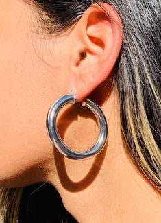 Crafted with meticulous attention to detail, these hoops showcase a generous size and a chunky design that commands attention. Embrace the bold and striking allure of the large chunky silver-plated hoops, adding a touch of modern elegance and self-assured style to your accessory collection. Hoop Size: 7.5mm x 45mm Width: 7mm Clasp: Push Back  Material: Stainless Steel with Rhodium-Hypoallergenic. Tarnish Resistant. We recommend keeping abrasive chemicals away from the jewelry for the items to la Chunky Small Hoop Jewelry, Chunky Hoop Jewelry, Hoop Earrings Big, Hoop Earrings Chunky, Large Silver Hoop Earrings, Thick Hoop Earrings, Hoops Silver, Chunky Hoop Earrings, Earrings Big