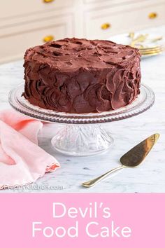 devil's food cake with chocolate frosting sitting on a plate next to a fork