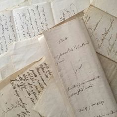 several old papers with writing on them sitting next to each other, all lined up together