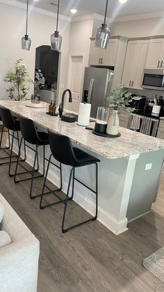 a kitchen island with four chairs in front of it and an open floor plan behind it