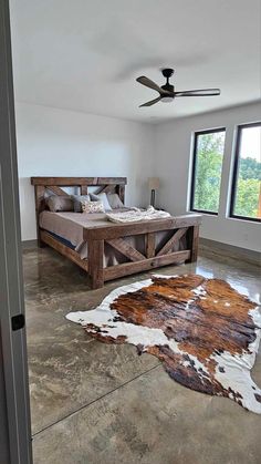 a bedroom with a large bed and cow hide rug on the floor in front of it