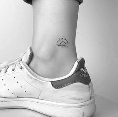 a woman's foot with a small tattoo on it