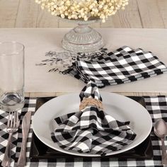 a place setting with black and white checkered napkins