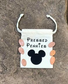 a bag with the words pressed pennies on it sitting on top of a rock