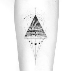 a black and white photo of a triangle tattoo on the right thigh, with mountains in the background