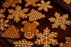 gingerbread cookies decorated with white icing and snowflakes on a baking sheet