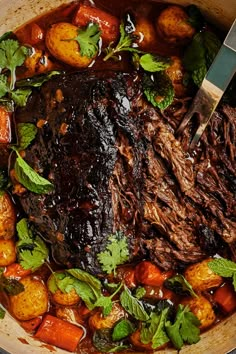 a pot filled with meat and vegetables on top of a table