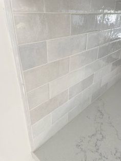 a bathroom with white tile and marble counter tops