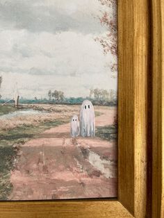 two white ghost figures walking down a dirt road in front of a painting on the wall