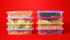 three plastic containers filled with different types of food on a red background, one containing broccoli and the other containing lettuce