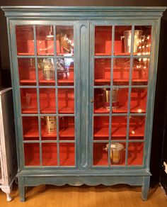 an old blue china cabinet with glass doors