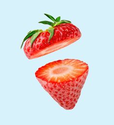 two strawberries flying in the air on a blue background with one being sliced open