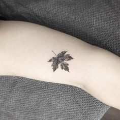 a small leaf tattoo on the arm