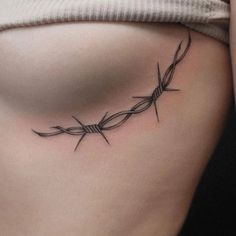 a woman's stomach with barbed wire tattoo on her side ribcadings