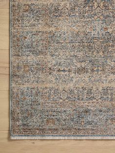 an area rug with blue and brown colors on top of a wooden floor next to a wall