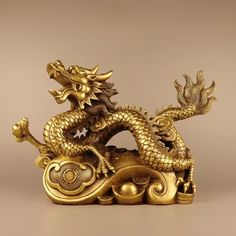 a golden dragon statue sitting on top of a table