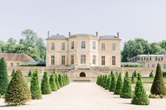 a large building with lots of trees in front of it and some bushes around the perimeter