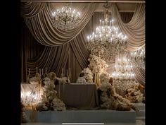 an elegant wedding setup with chandeliers and flowers