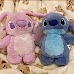 two stuffed animals sitting on top of a blanket