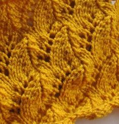 a yellow crocheted doily on a white surface with the top stitched off