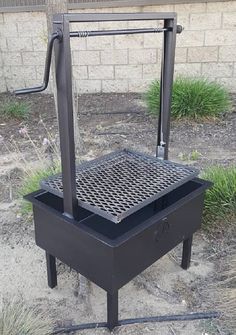 a black grill sitting on top of a dirt field