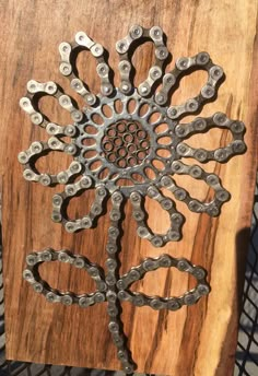 a piece of metal on top of a wooden board with holes in the center and an intricate design