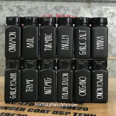 six black bottles with white writing on them