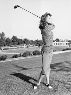 an old black and white photo of a woman playing golf