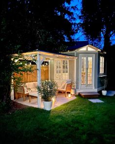 a small backyard with a gazebo and deck in the evening time, lit up by candles