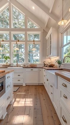 a large kitchen with white cabinets and wood flooring is pictured in this image from the inside