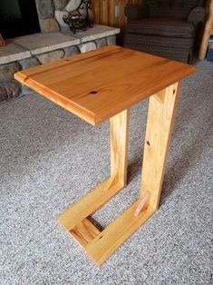 a wooden table sitting on top of a carpeted floor next to a fire place