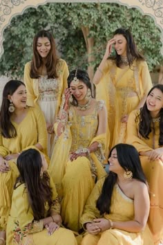 a group of women in yellow dresses sitting next to each other