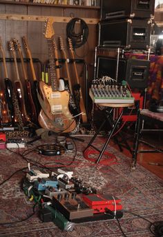 a room filled with guitars and amps on the floor