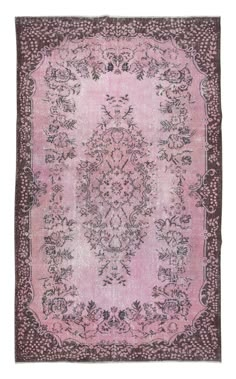 a pink rug with an ornate design on the center and sides, in various colors