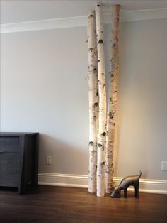 a pair of high heeled shoes sitting in front of two tall birch trees